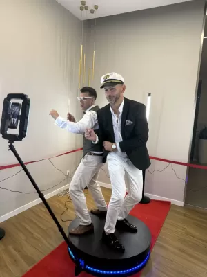 Fotobudka 360° na weselu w Radomiu, goście bawią się w nowoczesnej kabinie fotograficznej.