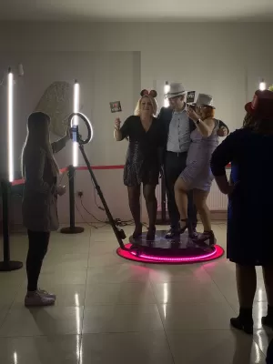 Fotobudka 360° na weselu w Zamościu, goście bawią się w obrotowej kabinie.